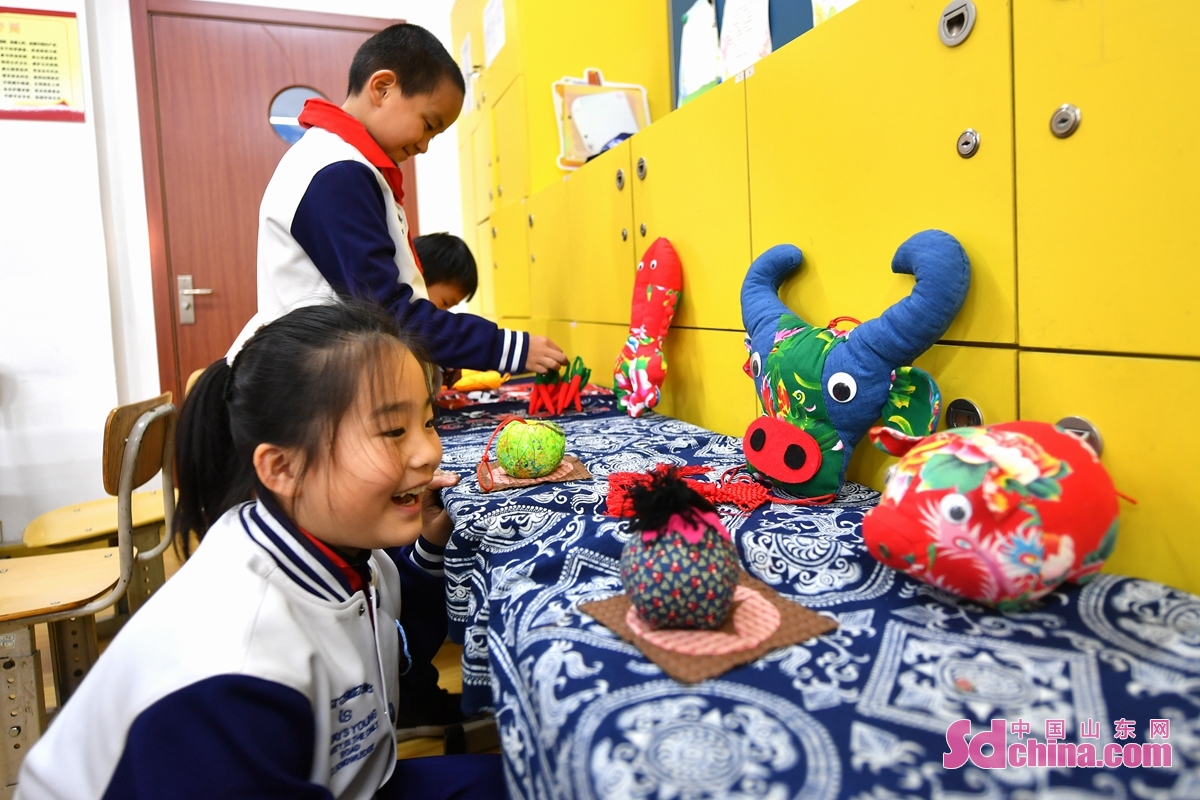 <br/>　　在山东省青岛市长阳路小学传统文化进校园活动上，一名学生观看民间手工布艺展示。