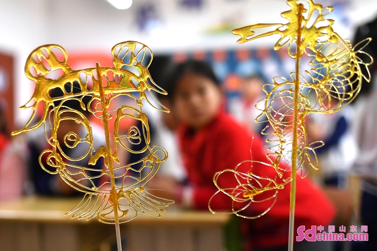 <br/>　　在山东省青岛市长阳路小学传统文化进校园活动上，学生们体验制作的糖画。<br/>