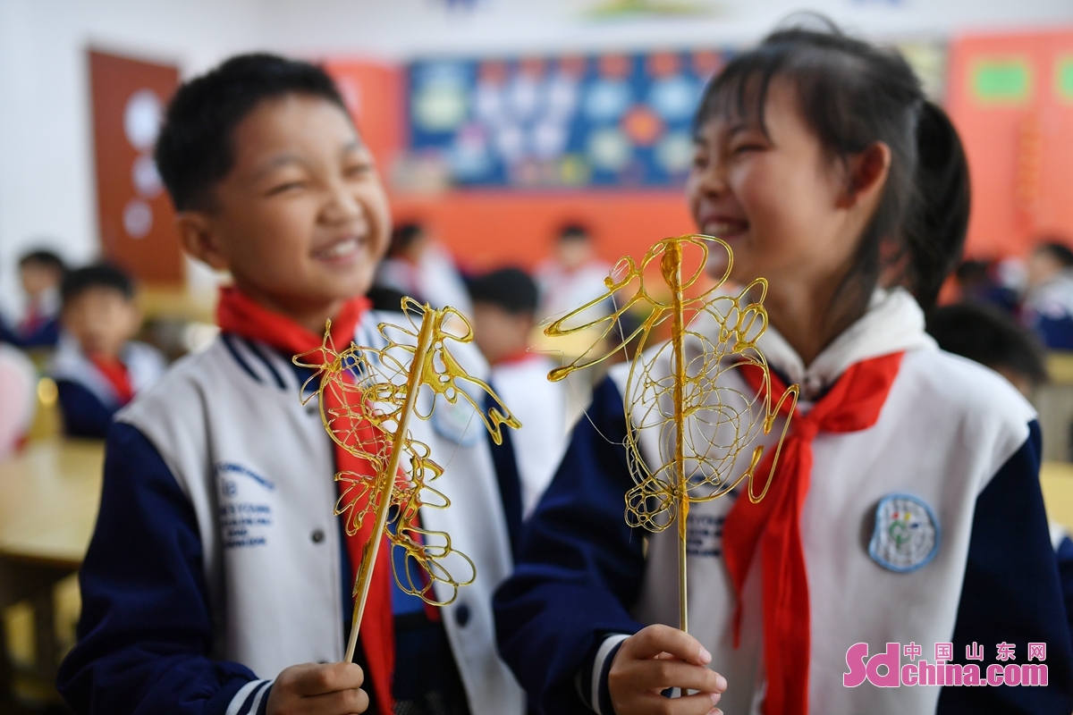 <br/>　　在山东省青岛市长阳路小学传统文化进校园活动上，两名学生比拼各自完成的生肖糖画。<br/>