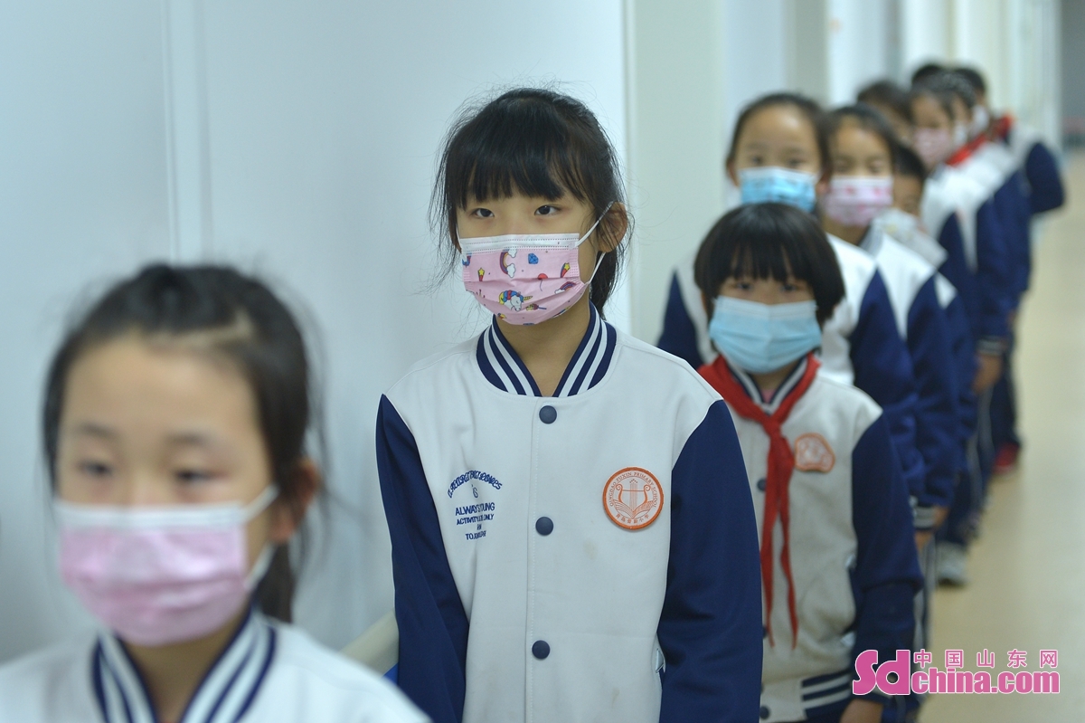Students receive COVID-19 vaccinate shots in Qingdao, East China&rsquo;s Shandong Province on Nov. 4, 2021. COVID-19 vaccination for people aged 3 to 11 is being rolled out across Qingdao to further improve the vaccine coverage rate and build the herd immunity barrier as soon as possible.