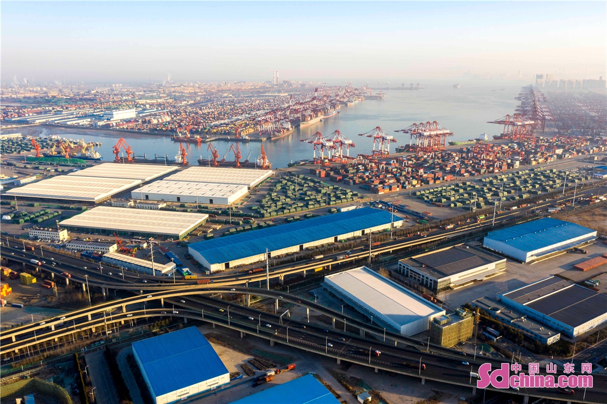  <br/>　　2021年12月31日清晨，山东港口青岛港前湾集装箱码头各个泊位上的集装箱船正在有序地装卸集装箱，港口一片繁忙景象。<br/>