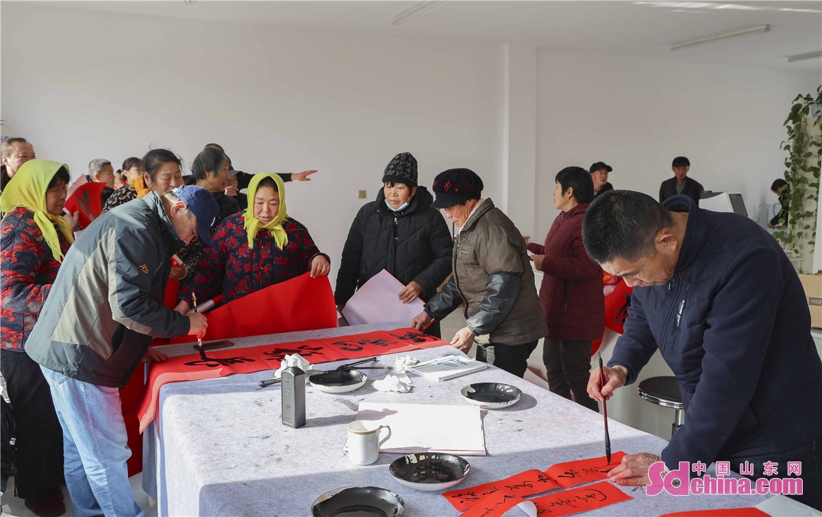 Four calligraphers are seen writing Spring Festival couplets for the community residents in Qingdao, China&rsquo;s Shandong province to greet the 2022 Spring Festival.<br/>