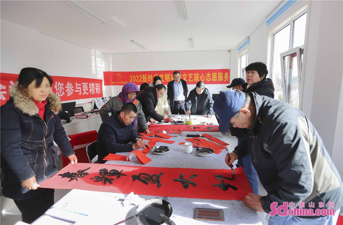 Four calligraphers are seen writing Spring Festival couplets for the community residents in Qingdao, China&rsquo;s Shandong province to greet the 2022 Spring Festival.