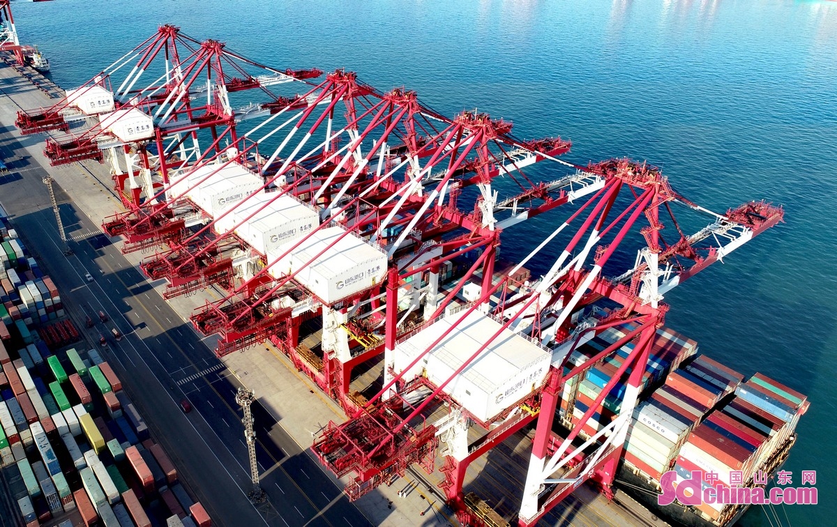 <br/>　　1月14日，在山东港口青岛港前湾集装箱码头，一艘货轮在装载货物。<br/>　　