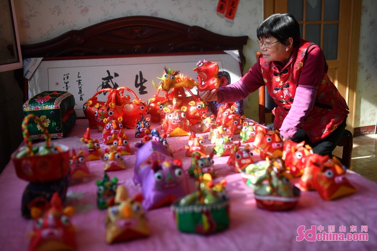 <br/>　　在青岛市城阳区河套街道，民间手艺人赵建美为春节赶制手工布老虎铺满床面。