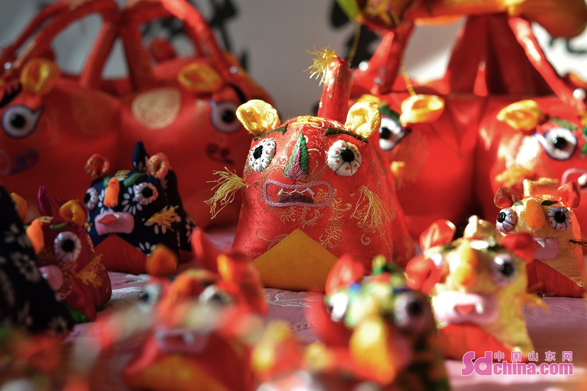<br/>　　在青岛市城阳区河套街道，民间手艺人赵建美为春节赶制手工布老虎铺满床面。<br/>