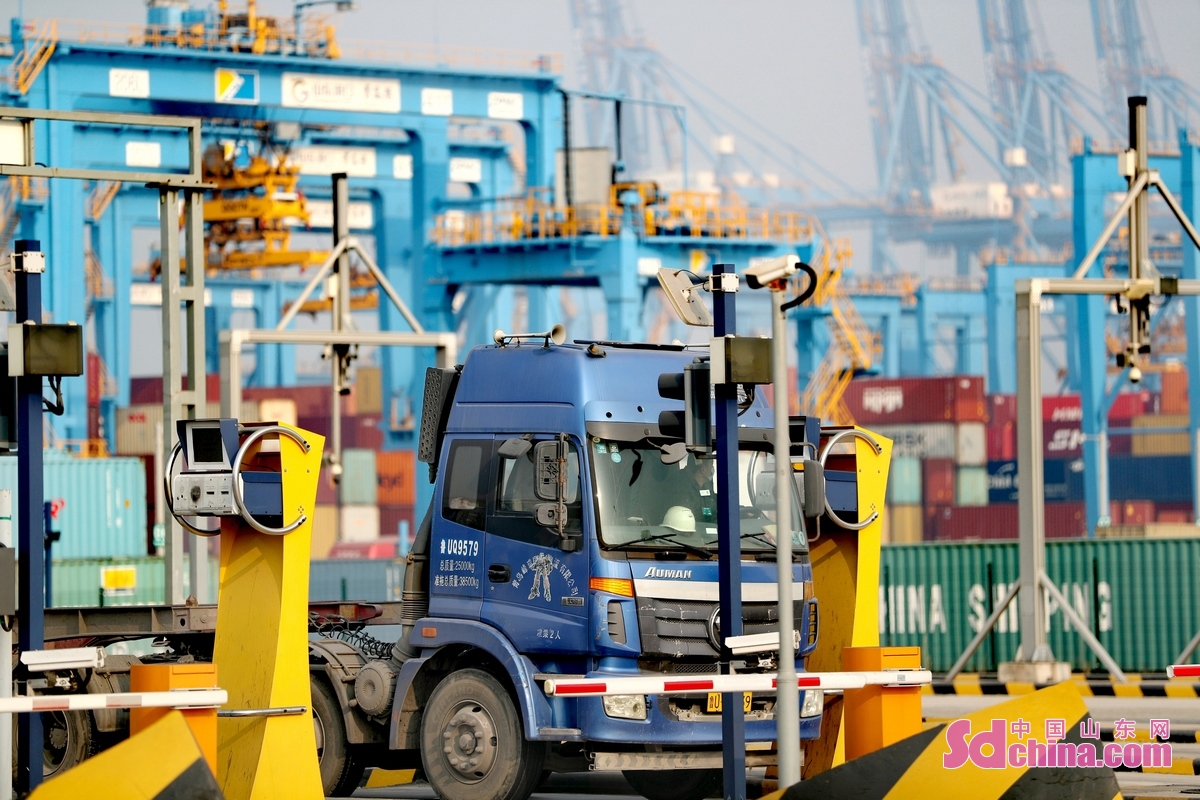 <br/>　　1月6日，在山东港口青岛港全自动化码头，一集装箱货车在打卡出港。<br/>　　