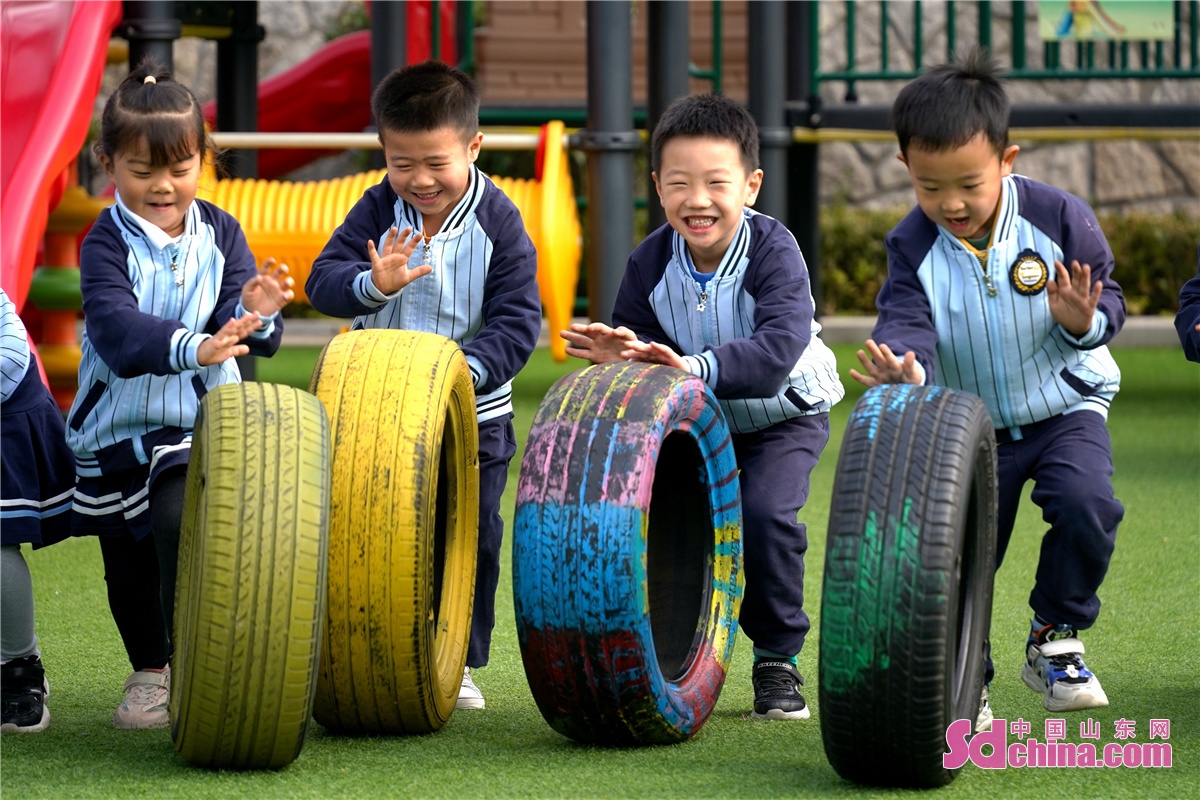 <br/>　　2022年11月1日，在山东省青岛市李沧区青峰路幼儿园，小朋友们进行滚轮胎游戏。张鹰 摄<br/>
