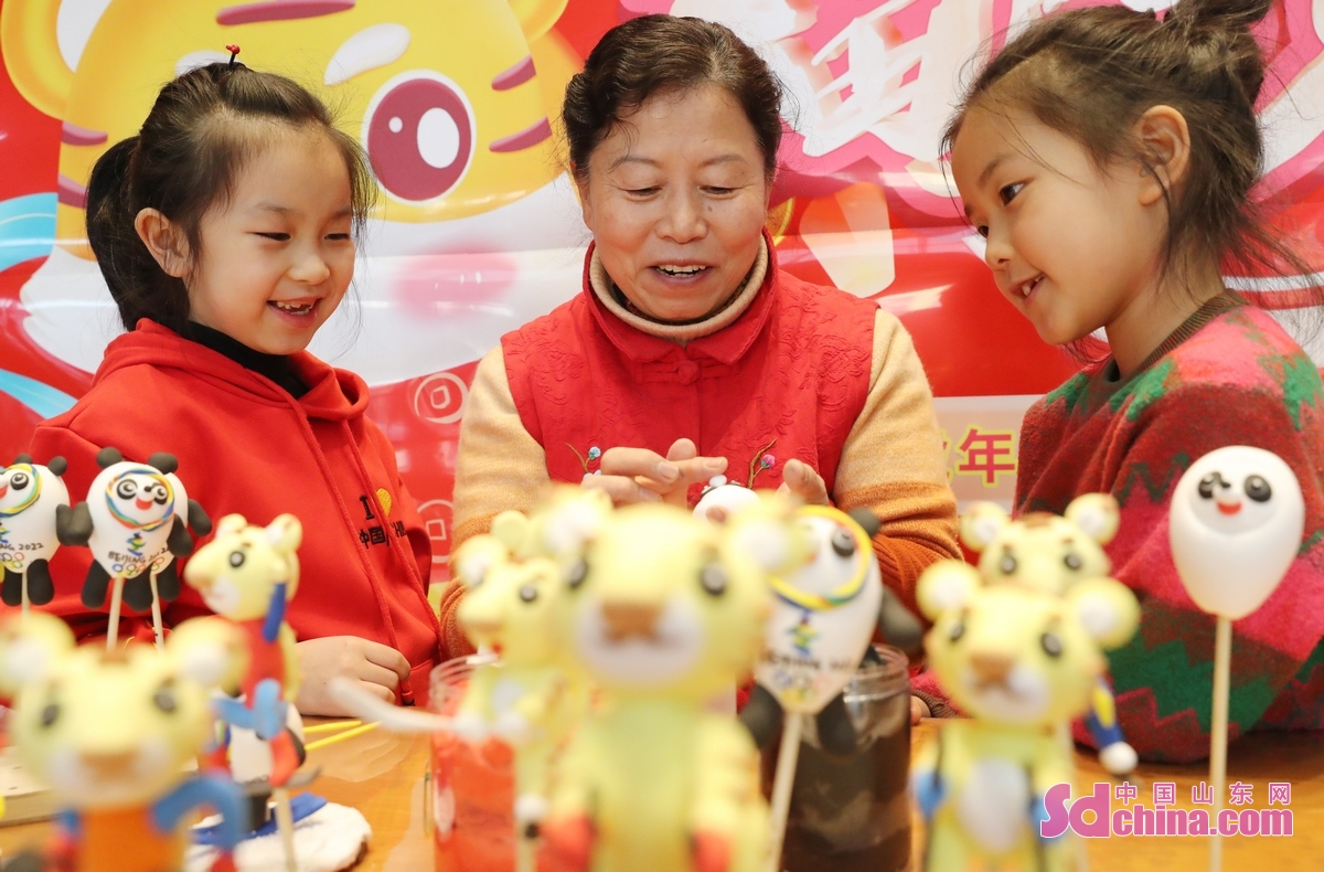<br/>　　2月10日，青岛西海岸新区民间艺人赵丽华在教两名小朋友如何制作面塑。<br/>　　