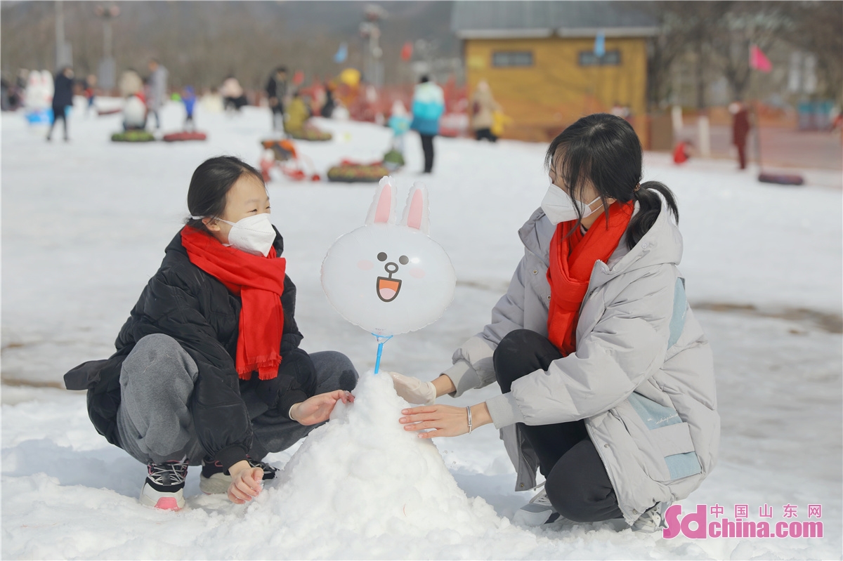  <br/>　　2023年1月22日，在山东省青岛市李沧区童梦园戏雪嘉年华，游客在堆雪人。张鹰 摄