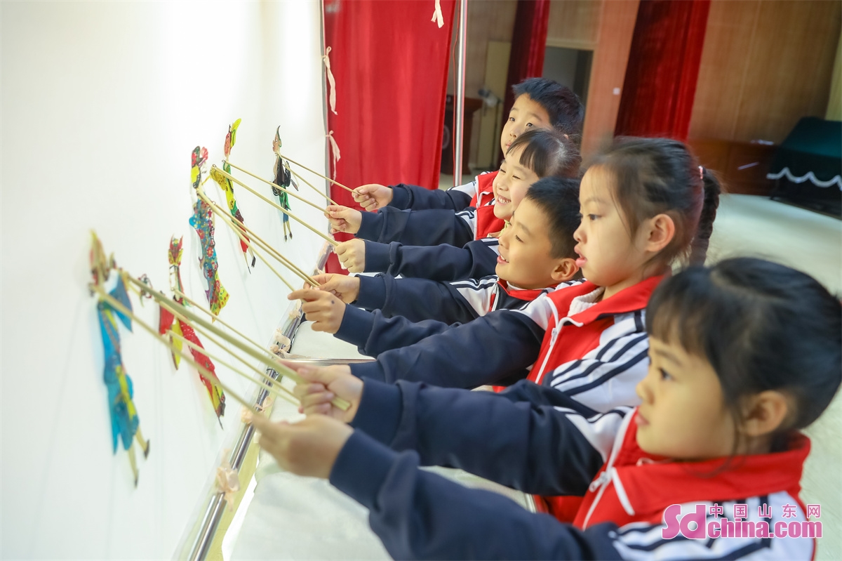 Students in Chongli Primary School in Qingdao, East China&rsquo;s Shandong Province, learn to make paper cuts and shadow puppetry, and paint on kites to feel the charm of Chinese intangible cultural heritage on Feb. 6, the first day of spring term. (Photo by Zhang Ying)<br/>