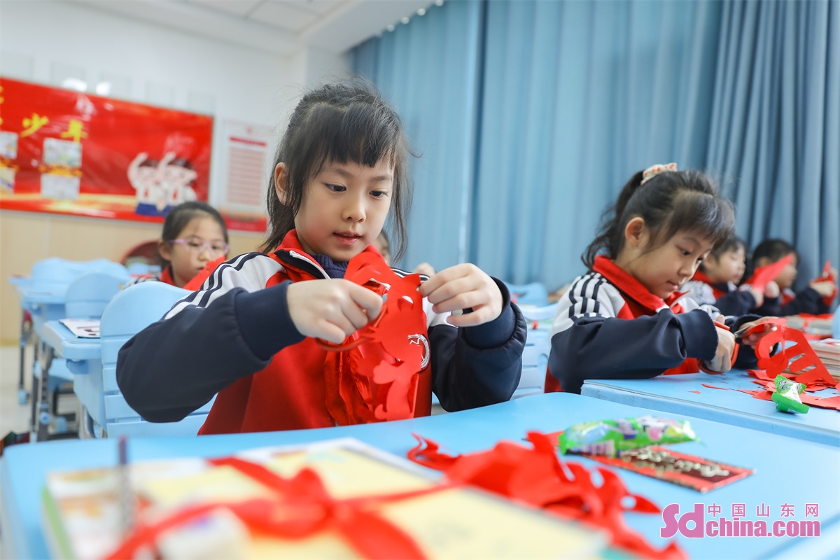 Students in Chongli Primary School in Qingdao, East China&rsquo;s Shandong Province, learn to make paper cuts and shadow puppetry, and paint on kites to feel the charm of Chinese intangible cultural heritage on Feb. 6, the first day of spring term. (Photo by Zhang Ying)