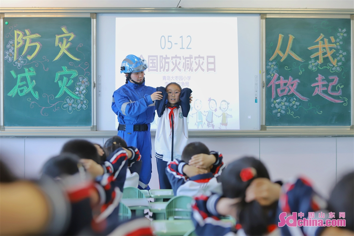 <br/>　　2023年5月11日，在山东省青岛大枣园小学，专业救援人员指导学生们学习地震避险动作要领。中国山东网发(张鹰 摄)<br/>