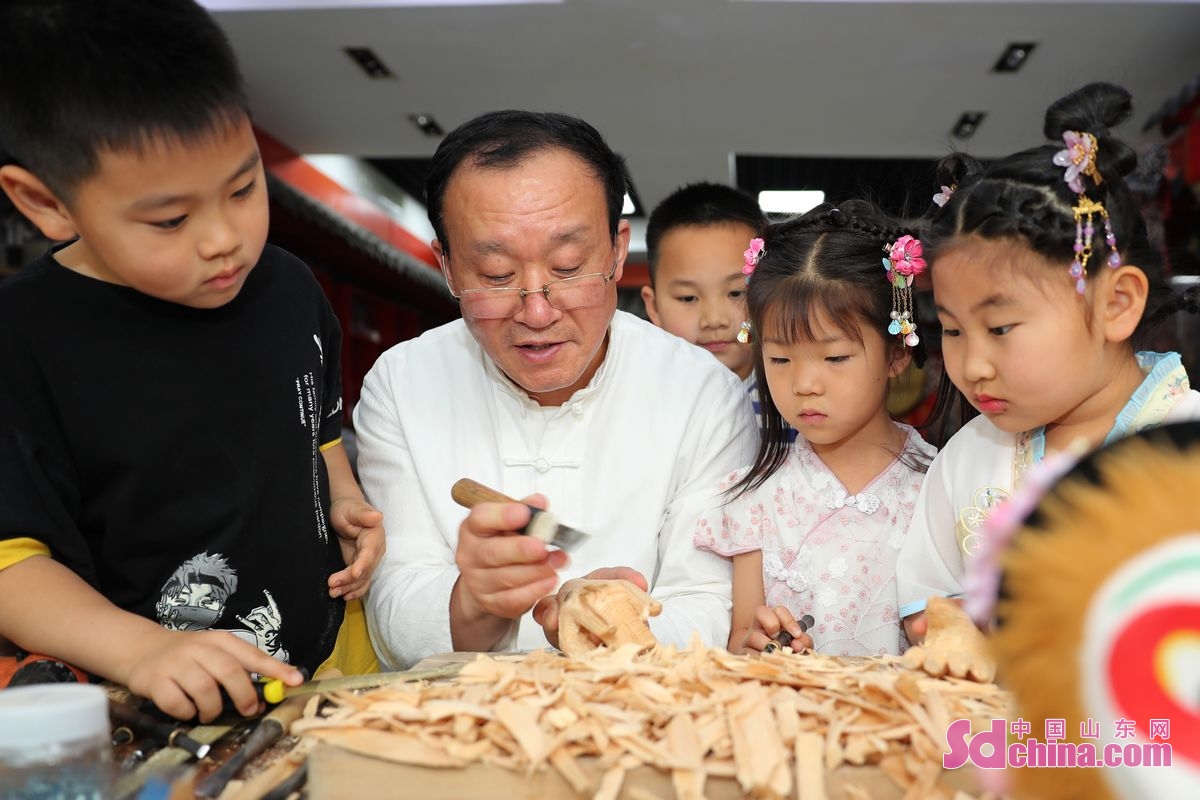 <br/>　　5月21日，姜玉涛（左）在给小朋友演示木偶戏的表演技巧。<br/>　　