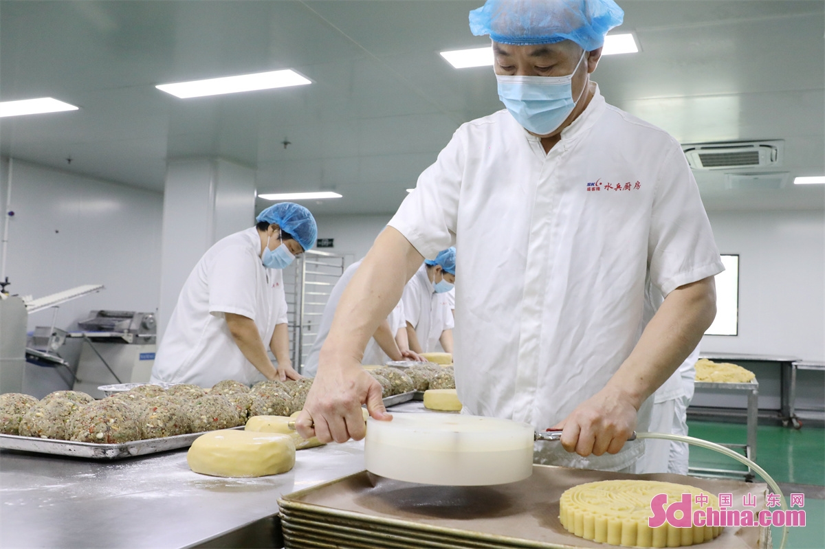 On September 13th, workers are seen stepping up production of large mooncakes to meet the market demand for the upcoming Mid-autumn Festival in a workshop in the Qingdao West Coast New Area, China&rsquo;s Shandong Province.<br/>The &ldquo;Family Reunion&rdquo;handmade mooncakes produced by the company have a history of nearly 20 years. The mooncakes use an improved version of the five-nut filling, each weighing 3 kilograms. Due to the use of traditional recipes and craftsmanship, as well as the meticulous selection of ingredients, they are deeply loved by consumers. (Photo by Wang Peike)<br/>