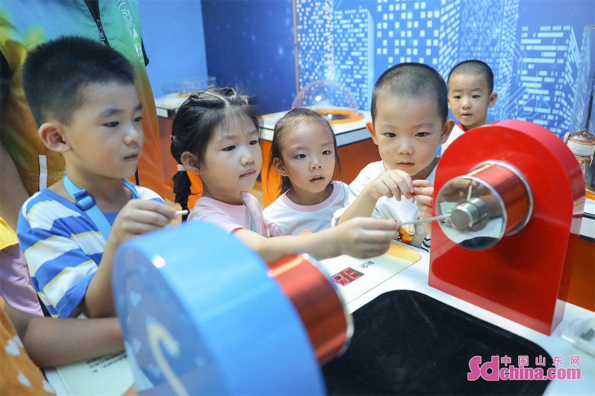 <br/>Children are seen experiencing the fun of scientific experiments through hands-on activities such as hand-eye coordination, dancing paper clips, and sound standing waves at a Science Popularization Museum in Qingdao City, Shandong Province. (Photo by Zhang Ying)<br/>