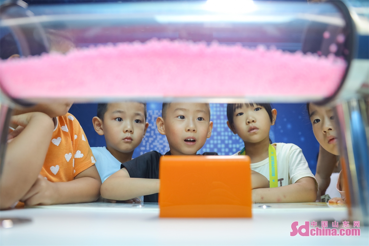  <br/>Children are seen experiencing the fun of scientific experiments through hands-on activities such as hand-eye coordination, dancing paper clips, and sound standing waves at a Science Popularization Museum in Qingdao City, Shandong Province. (Photo by Zhang Ying)<br/>