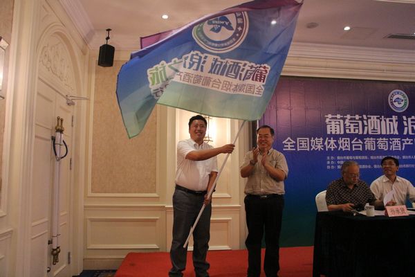 中共烟台市委宣传部常务副部长李明向采访团授旗