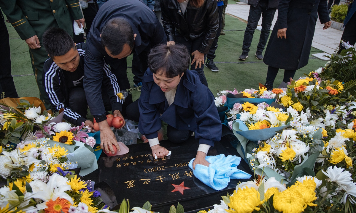 Yang Suxiang sweeps the tombstone of her son Wang Zhuoran, a martyr sacrificed in the China-India border clash in June 2020, with a towel in Luohe, Central China''s Henan Province on Saturday. Photo: Li Hao/GT