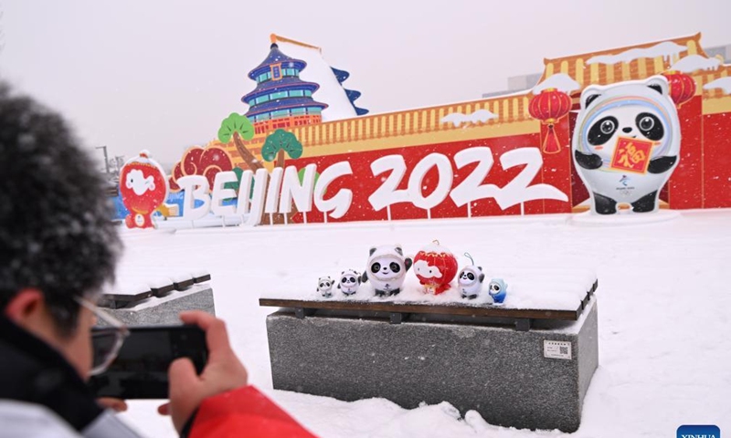 A man takes photos of the mascots of Beijing 2022 Winter Olympics ad Paralympics outside the Main Media Center of Beijing Winter Olympics in Beijing, capital of China, Feb. 13, 2022. (Xinhua/Wu Wei)
