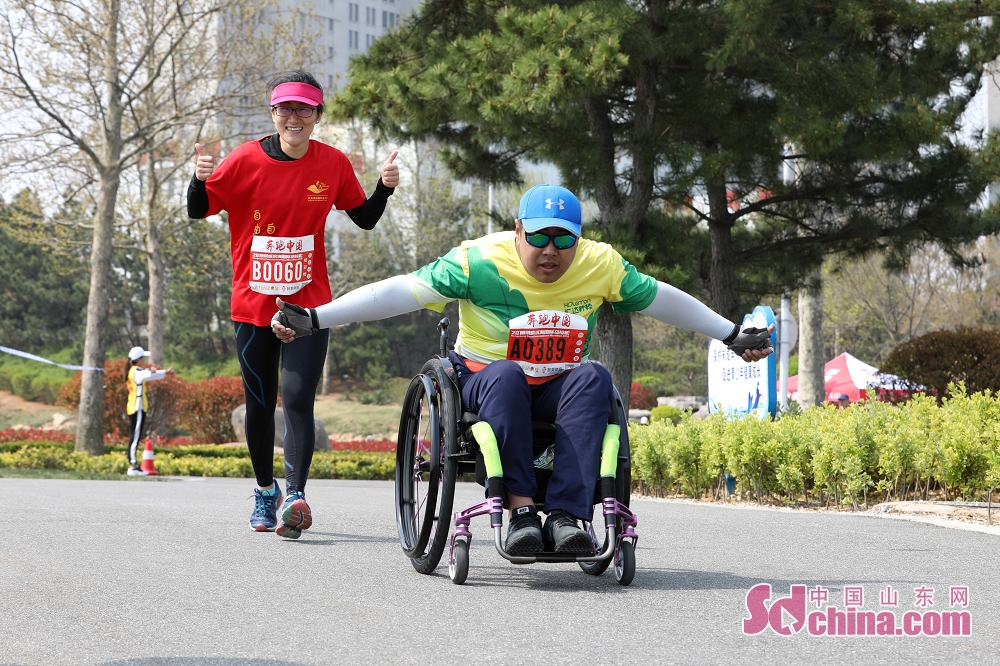 4月29日,在2018荣成滨海国际马拉松比赛现场拍摄的一名坐着轮椅的
