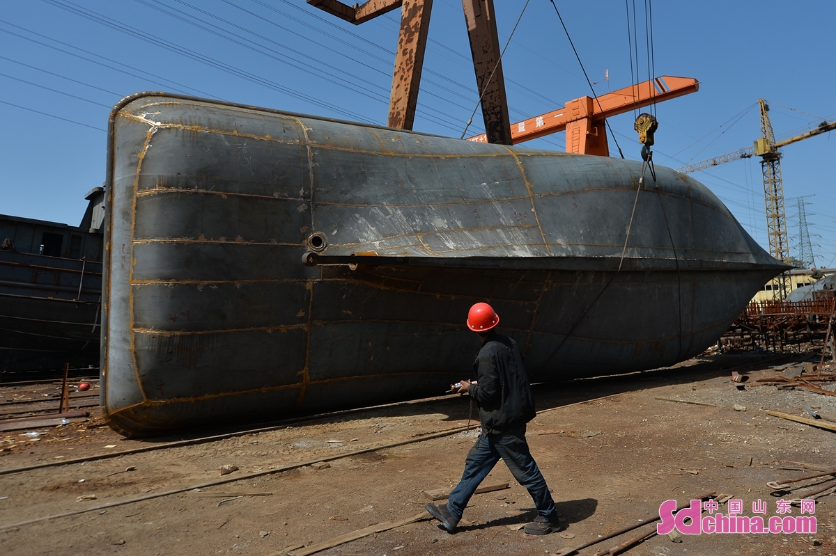  br/>  工人在青岛宝航船舶修造有限公司制造工地利用吊车转体新渔船.